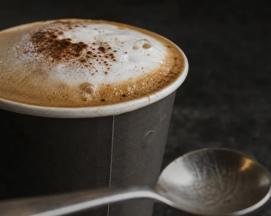 Cappuccino, a finished Rhine Coffee drink photographed on a dark wooden table