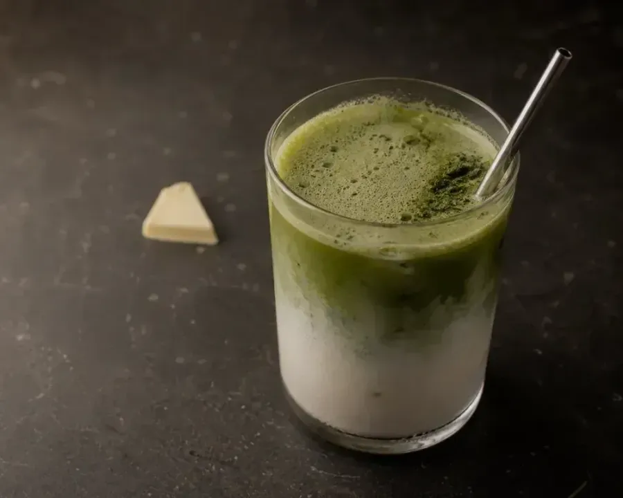 Matcha White Choco Latte, a finished Rhine Coffee drink photographed on a dark wooden table